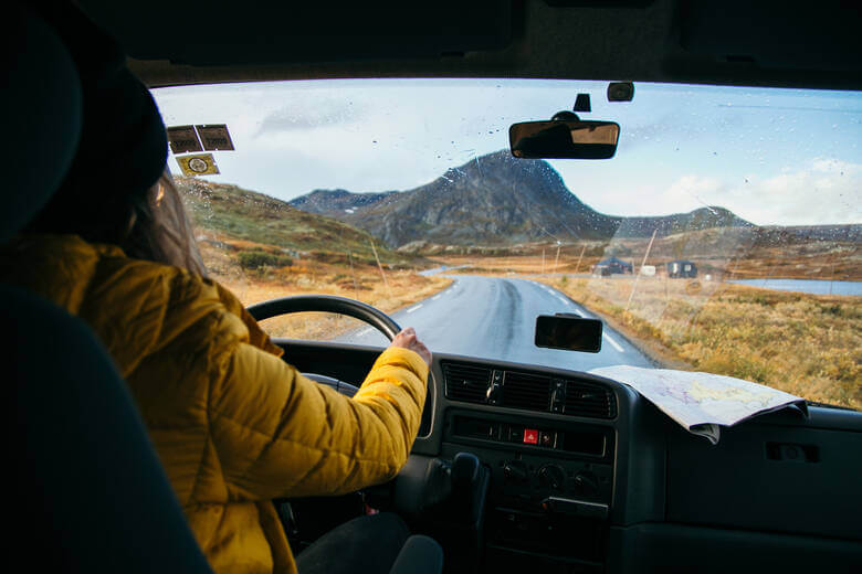 Frau fährt mit einem Camper durch Island