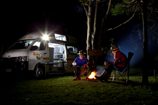 Camper mit Lagerfeuer nachts in Neuseeland