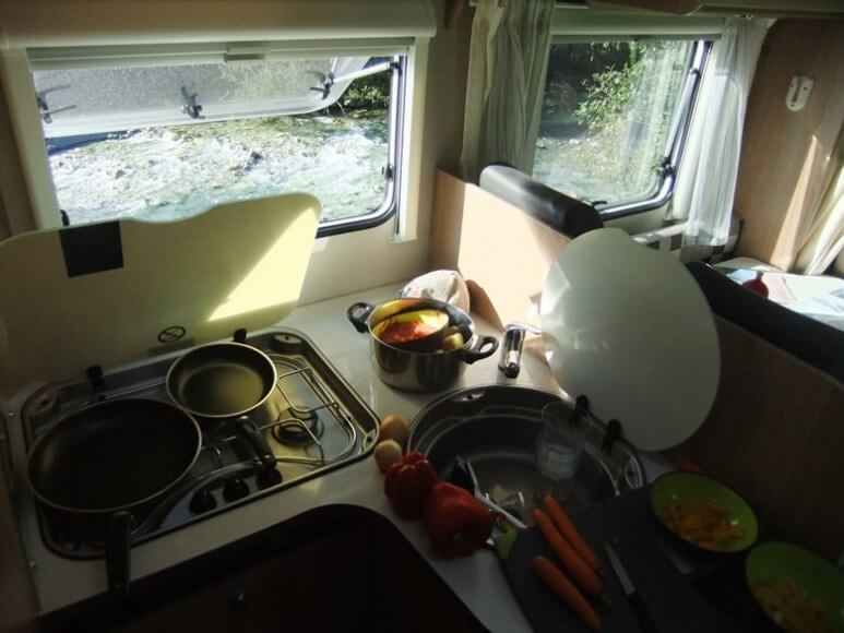 Kochen im Wohnmobil mit Blick auf Fluss in der Schweiz