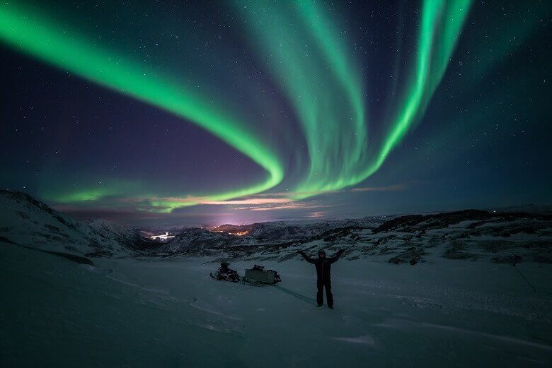 Schneemobil unter den Polarlichtern im Norden von Norwegen