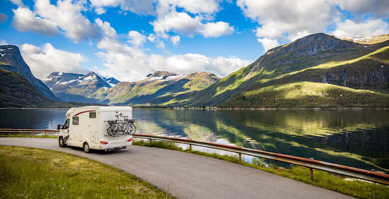 Nachhaltig reisen: Wohnmobil mit Fahrrädern fährt durch die Natur.