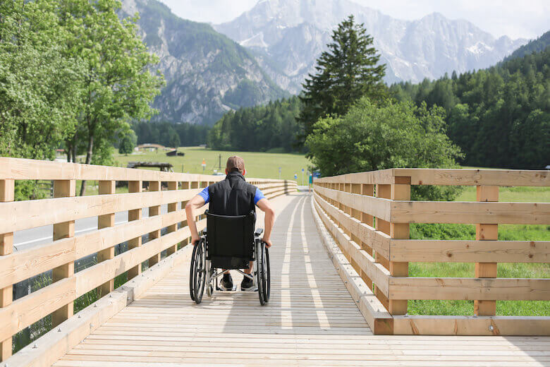 Rollstuhlfahrer nutzt barrierefreie Wege auf einem Ausflug in der Natur.