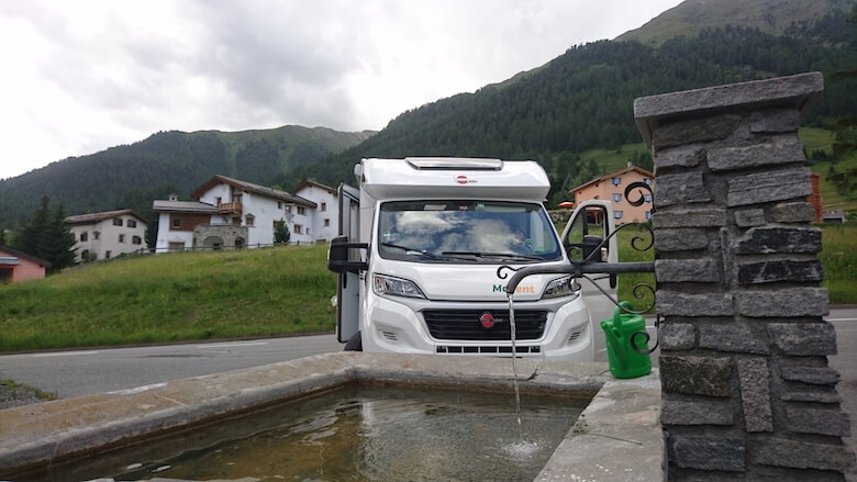 Wohnmobil an einem Dorfbrunnen