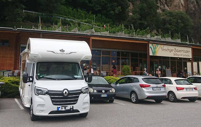 Wohnmobil steht vor einem Hofladen im Vinschgau.