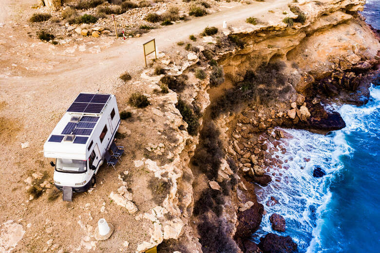 Camper mit Solarzellen an Küste