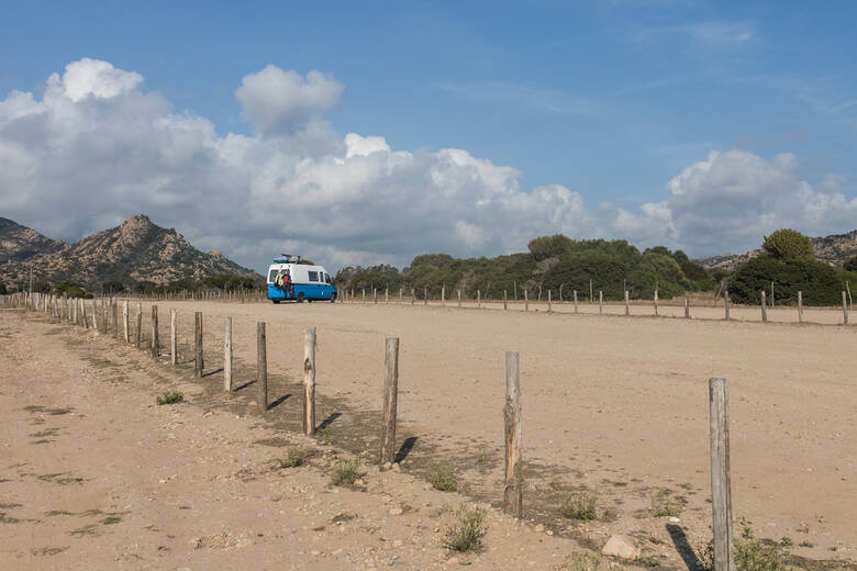 Camper parkt auf dem Parkplatz am Strand Berchida auf Sardinien