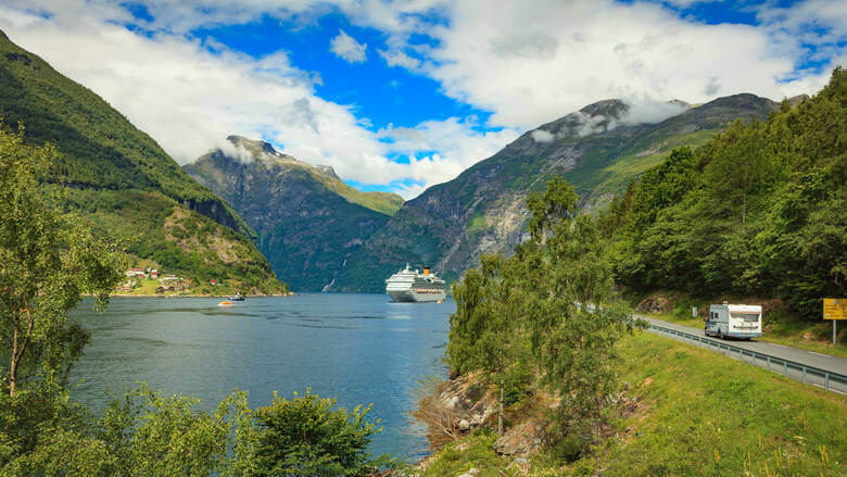 Geirangerfjord mit Kreuzfahrtschiff und Wohnmobil auf Straße