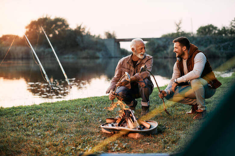 Camping und Angeln: Angler bereiten ihren selbst gefangenen Fisch auf dem Campingplatz zu.