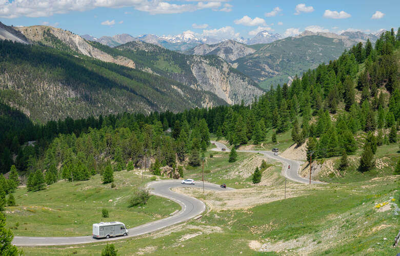 Wohnmobil fährt über Serpentinen in den Alpen