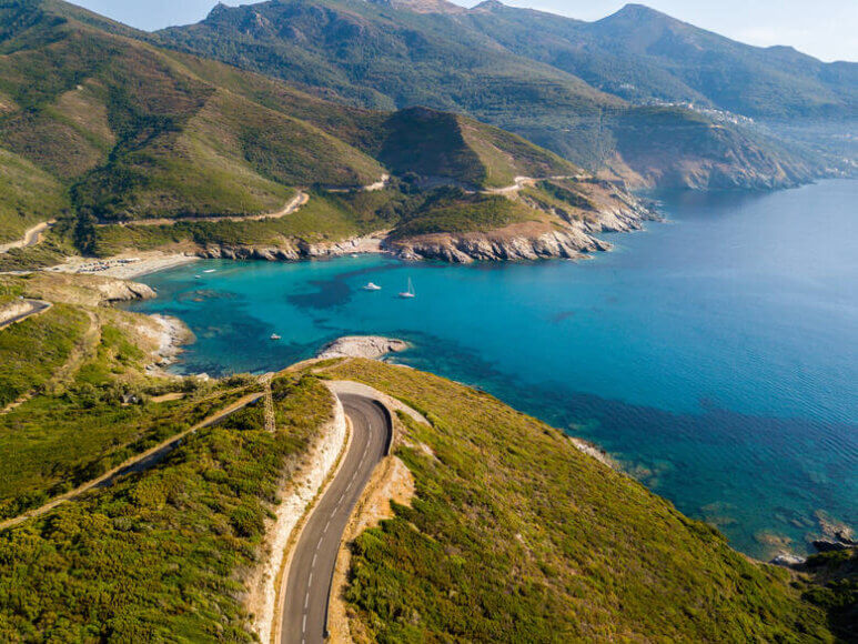 Küstenstraße auf der Insel Korsika mit Berglandschaft im Hintergrund