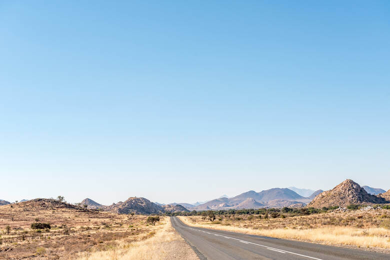 Straße führt durch die Trockenebene von Namibia