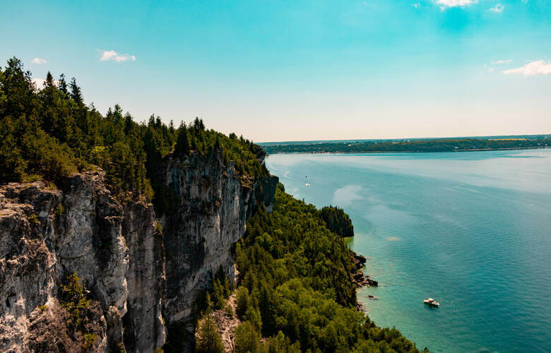 Weiße Kalksteinfelsen, grüne Tannen und ein blauer See