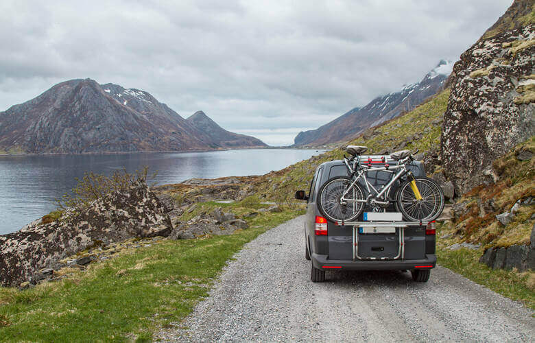 Camper mit Fahrradträger auf einer Schotterstraße in Island