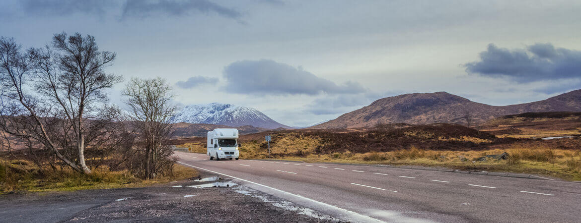 Wohnmobil fährt auf einer Straße in den schottischen Highlands