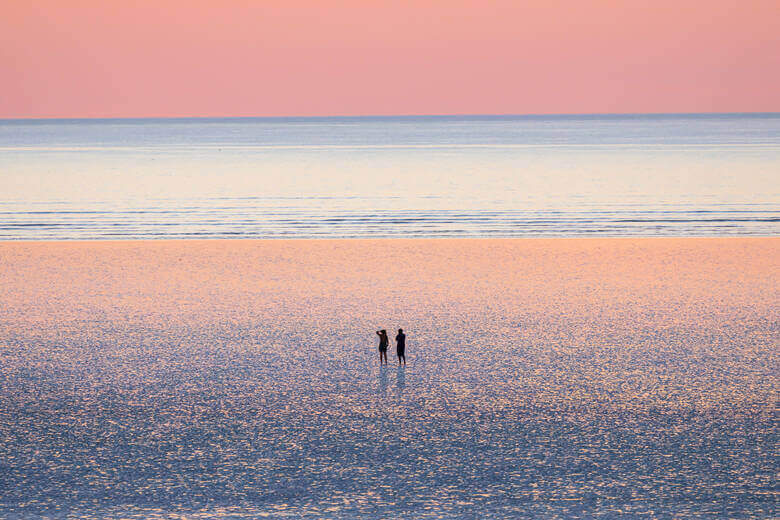 Ein Pärchen genießt den Sonnenuntergang an einem Strand in Westaustralien