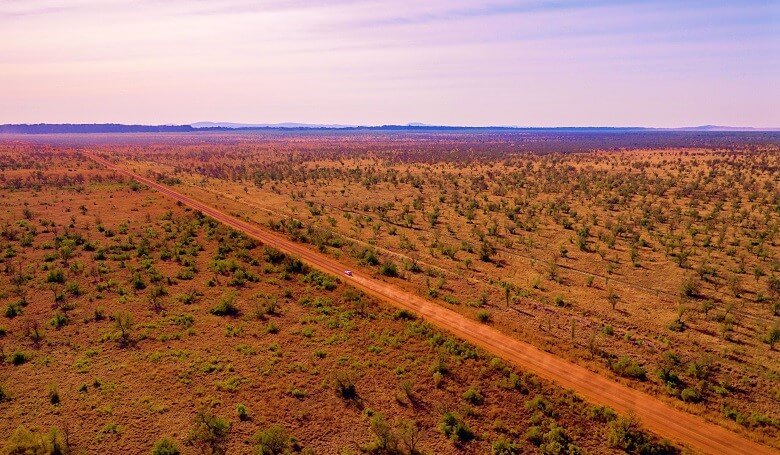 Wohnmobil fährt durch das orangerote Outback in Westaustralien