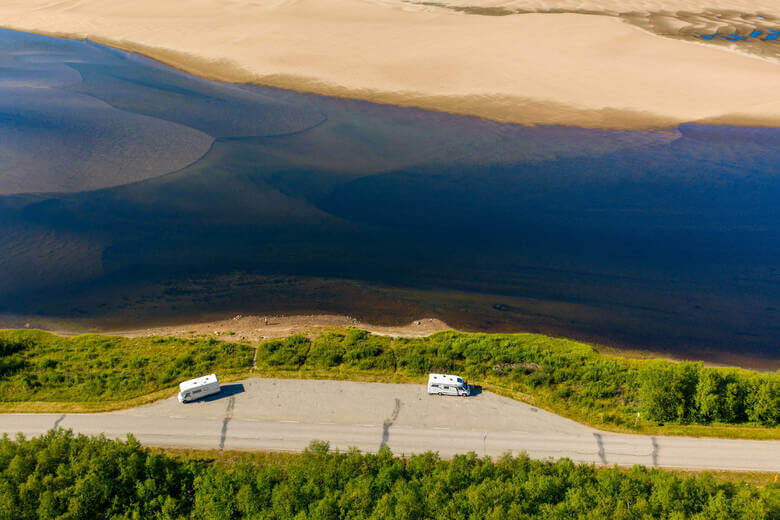 Zwei Wohnmobile stehen in Finnland am Wasser