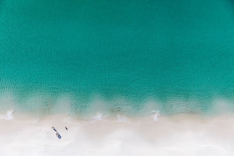 Blaues Wasser und weißer Sand an einem Strand in Australien 