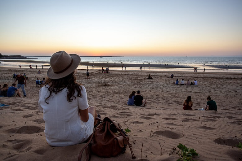 Frau beobachtet einen Sonnenuntergang an einem Strand in Australien