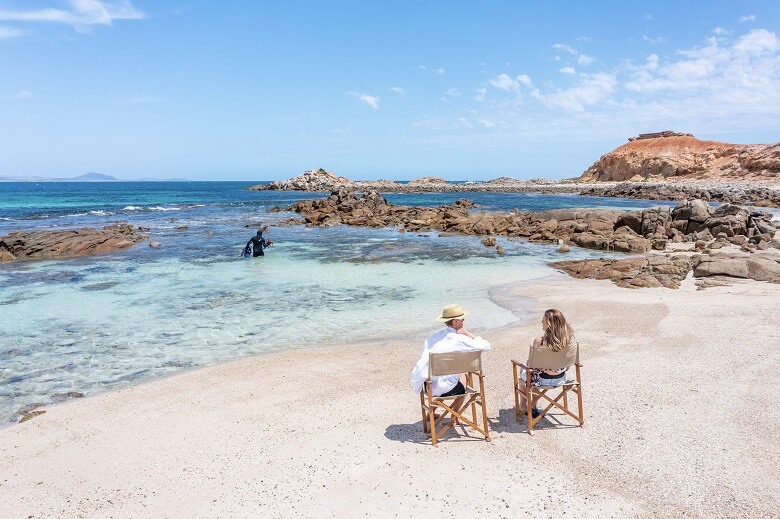 Paar entspannt in Klappstühlen an einem australischen Strand 